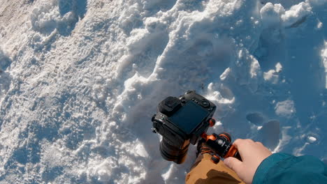 a man trekking a snowy winter mountain with his camera on his hand