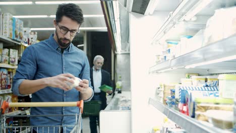 hombre eligiendo productos lácteos en la tienda