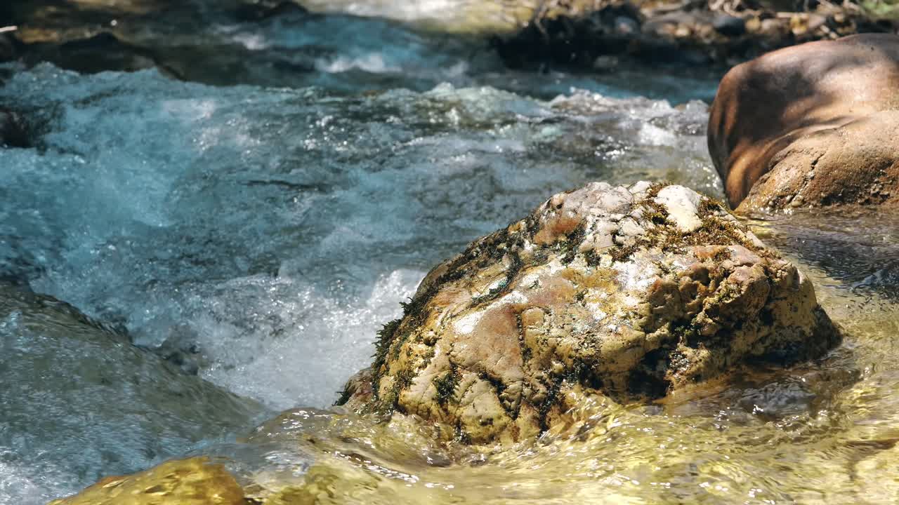Acqua cristallina che scorre tra le rocce in una giornata di sole