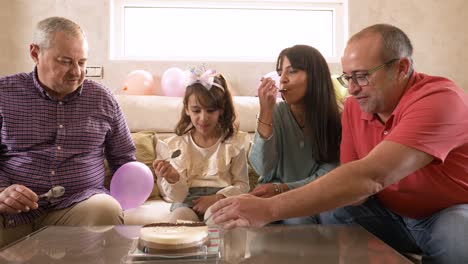non-normative family enjoying eating a birthday cake at home