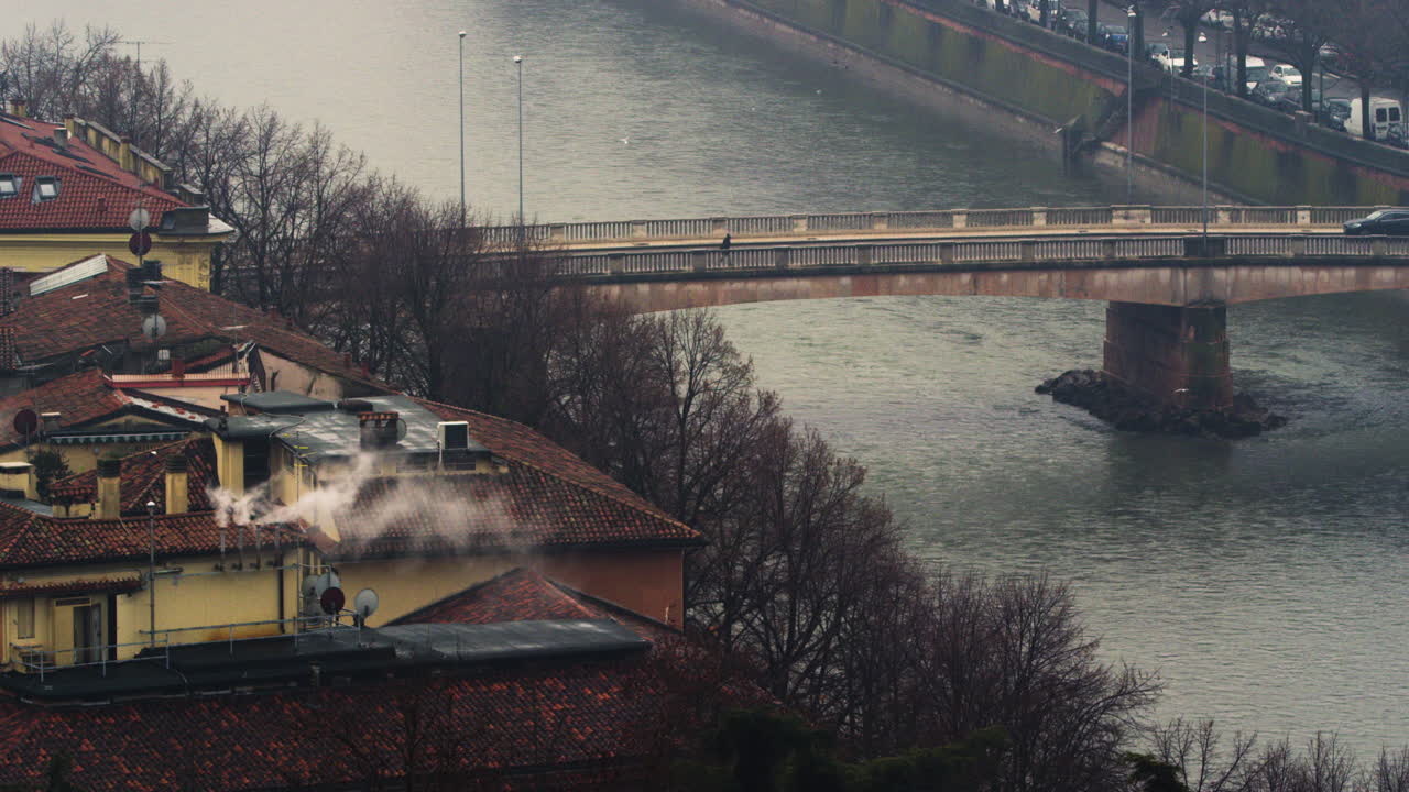 Immagine fissa del fiume Adige e dei palazzi in una giornata cupa.
