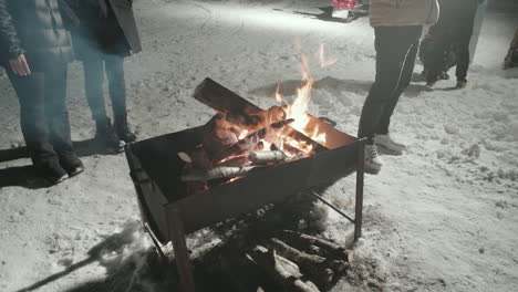 close up of campfire with people standing around in gifu, japan on a cold winter night