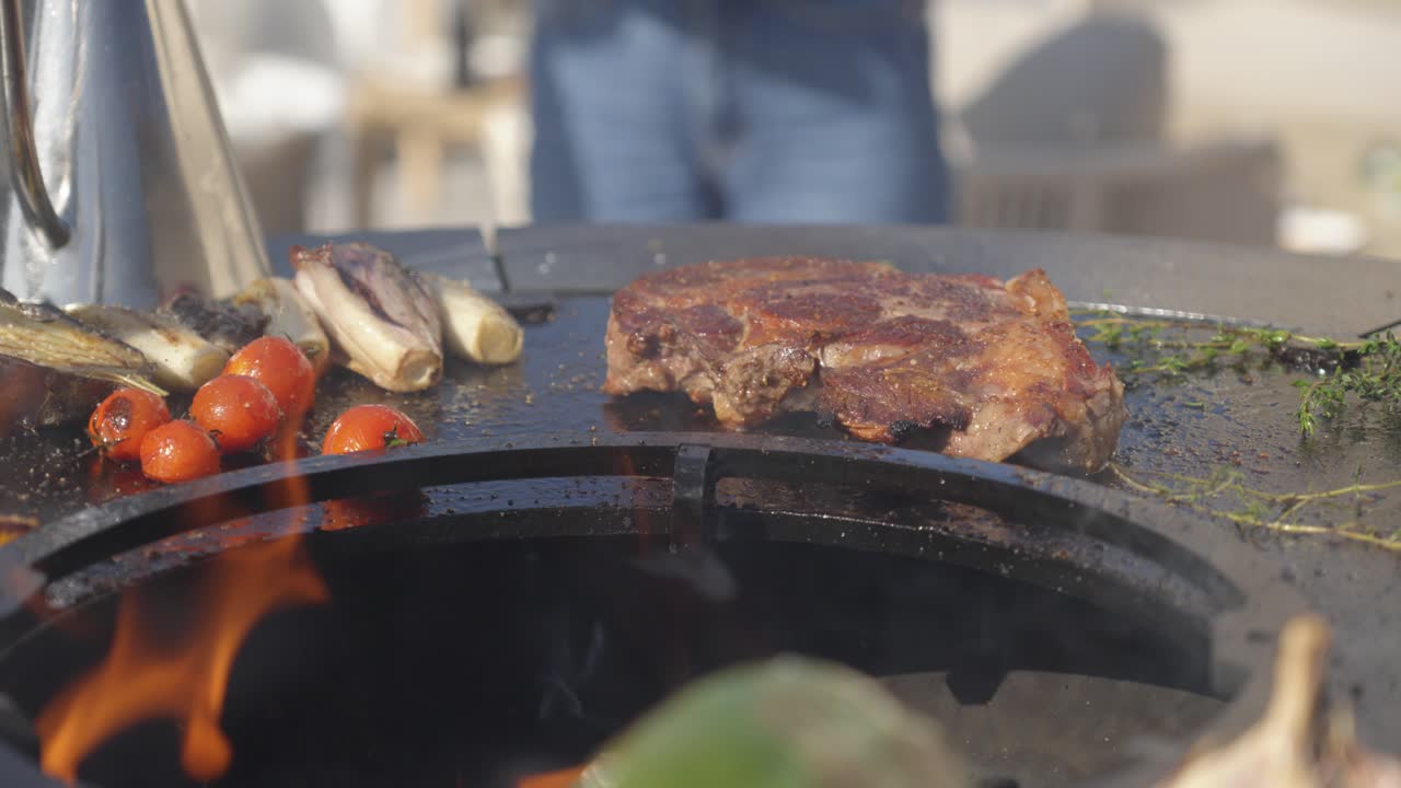 Sizzling steak and fresh vegetables grilling on an outdoor barbecue