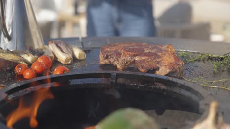 sizzling steak and fresh vegetables grilling on an outdoor barbecue