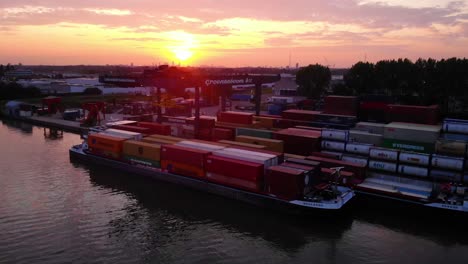 golden hour sunset at the port of alblasserdam in netherlands with container vessel anchored for loading