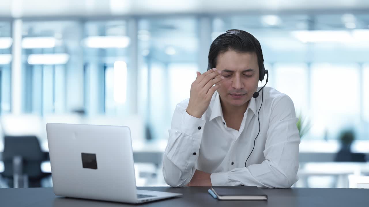 Impiegato di call center indiano stressato che parla con un cliente