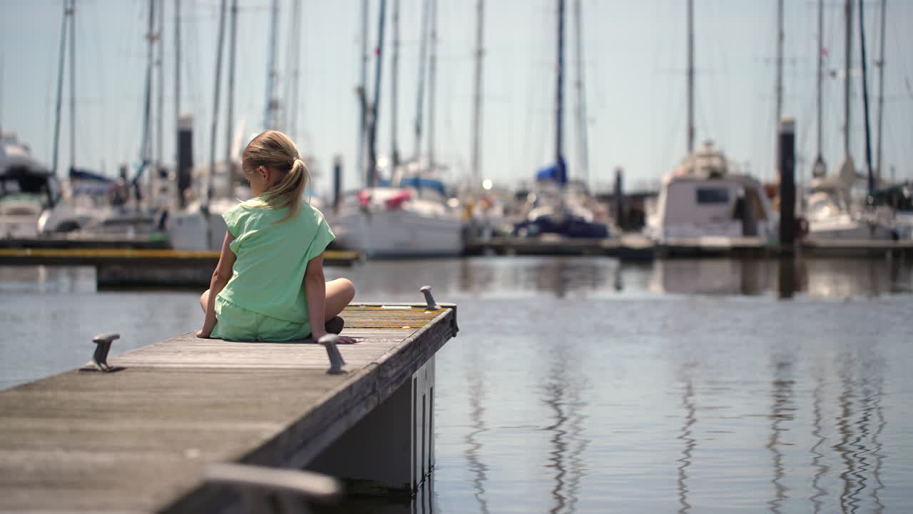 Young girl exploring a marina dock