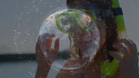 adjusting snorkel mask, woman with digital globe and network animation overlay