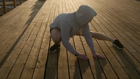 man stretching on wooden deck