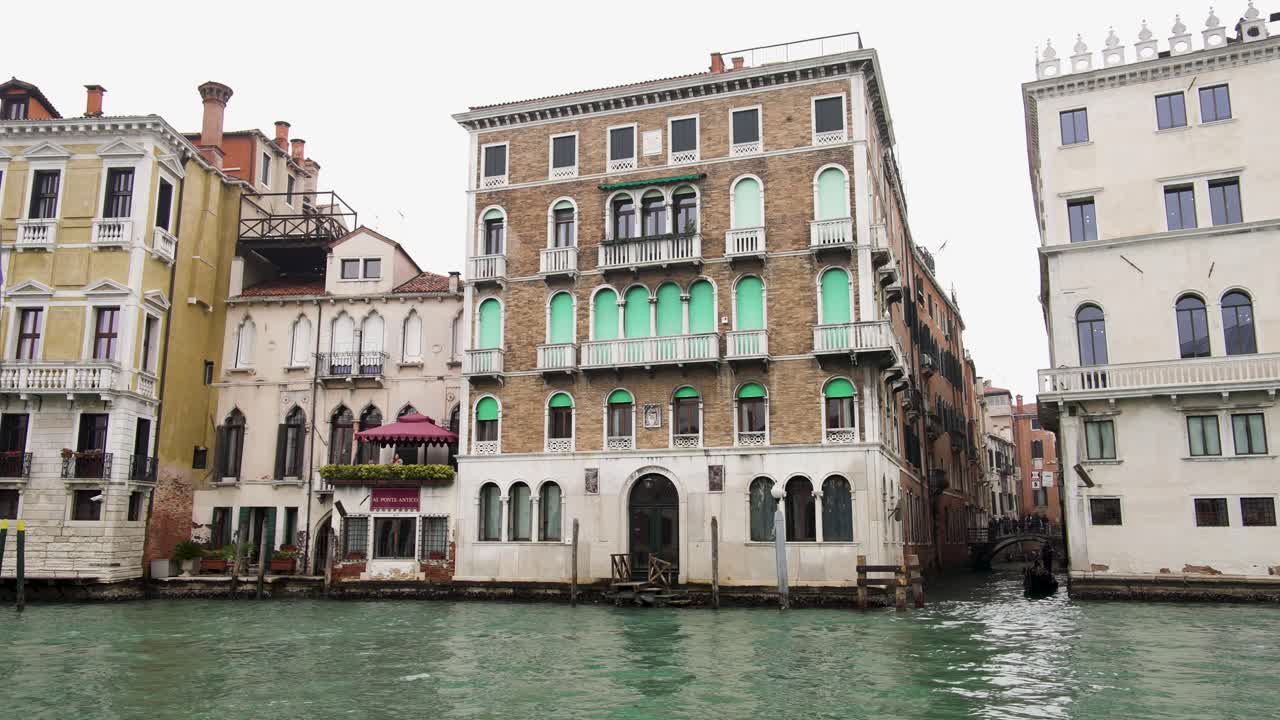 Canal building with gondola and motorboat passing through water, Italy