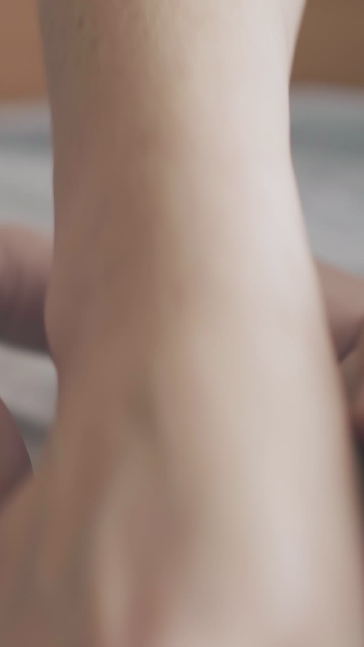 professional pediatrician massages newborn boy with hypertonus lying on special table actively extreme close view