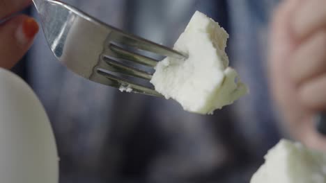 persona comiendo cubos de queso con un tenedor