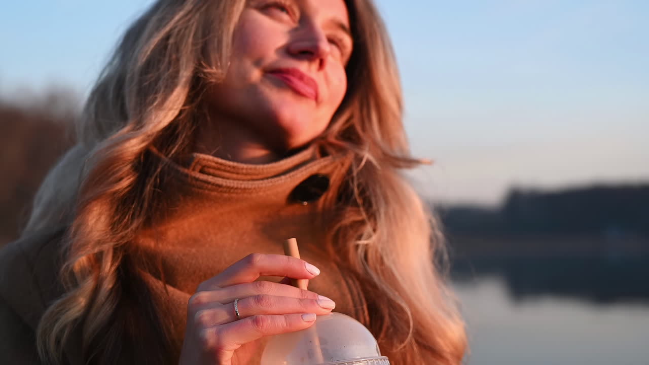 Giovane donna mescola il caffè con una cannuccia di bambù e lo beve