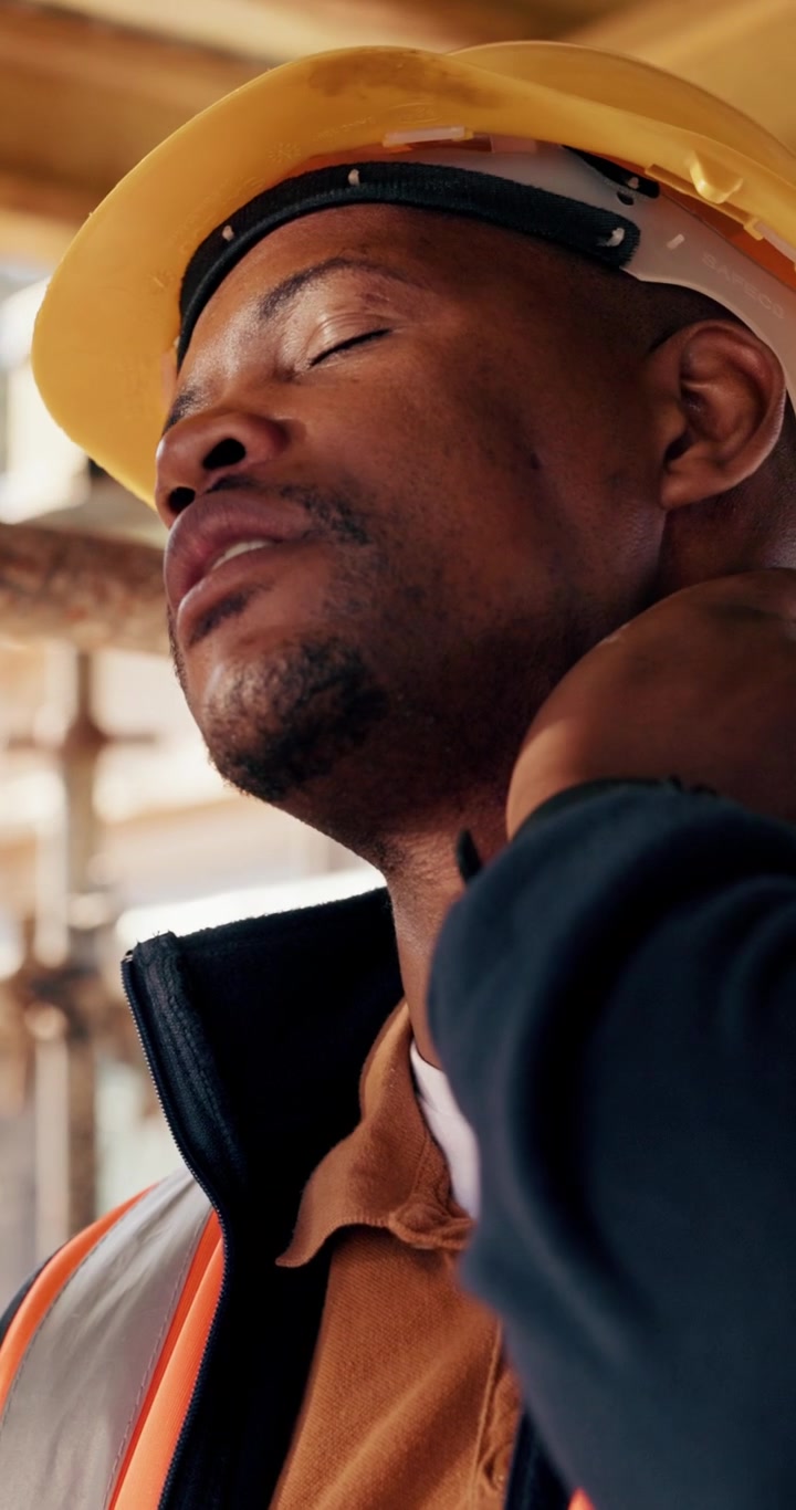Tired Construction Worker Rubbing His Neck on Site