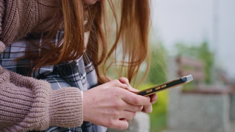 teenage girl texting on smartphone in park