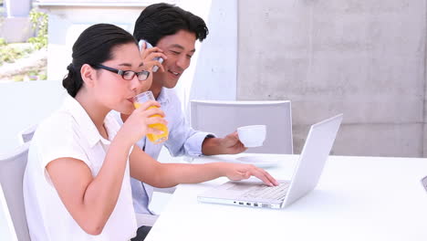 asian couple using laptop together in the morning