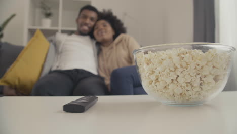 details of a remote control a bowl of popcorn