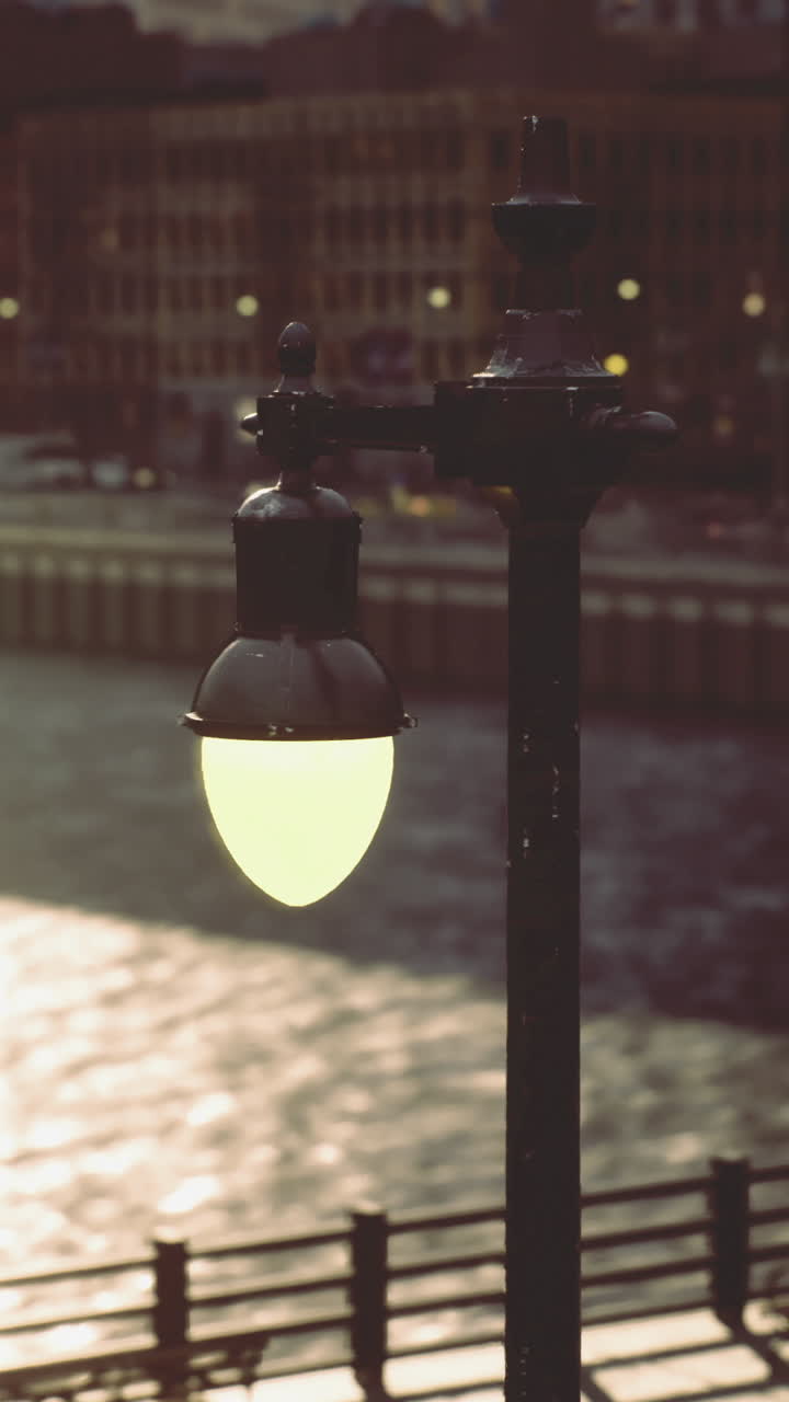 Sunset view along the river with glowing streetlights and water reflections