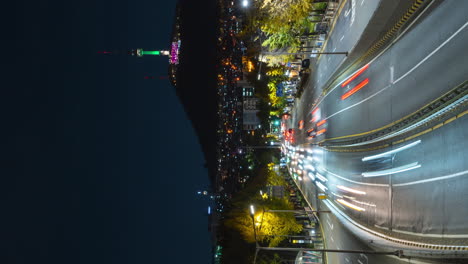 Seúl-Itaewon-Otoño-Tráfico-Intenso-Lapso-Nocturno-Con-Vista-De-La-Torre-Iluminada-De-Seúl-En-La-Montaña-Namsan---Alto-ángulo-Vertical