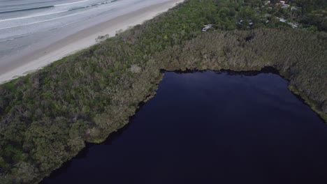 Flying-Over-Ti-Tree-Lake-Aboriginal-Area-Near-Broken-Head-Beach-In-Byron-Bay,-NSW,-Australia