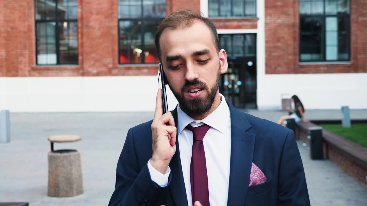 Uomo in giacca e cravatta che parla al telefono all'aperto