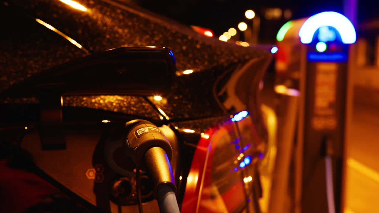 Close up of a red, electric car charging at night
