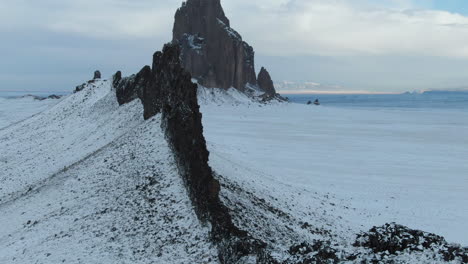 4k aerial reveal of shiprock monument covered in snow in new mexico, usa