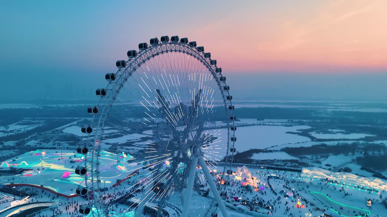 Aerial drone shot of snowflake Ferris wheel at sunset with beautiful colors at Harbin Ice Festival in Heilongjiang, China