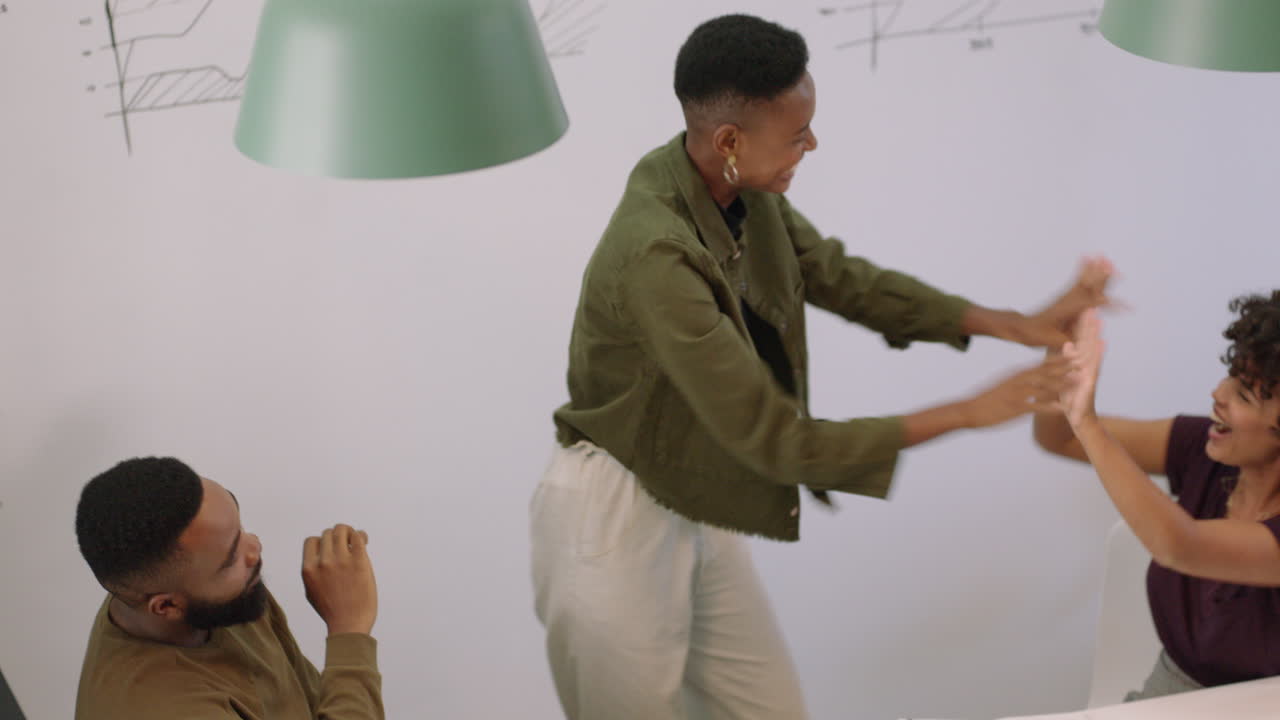 hombres de negocios negros exitosos celebrando el éxito disfrutando de la victoria corporativa presentación líder del equipo mujer emocionada bailando divertido en la sala de juntas reunión vista superior