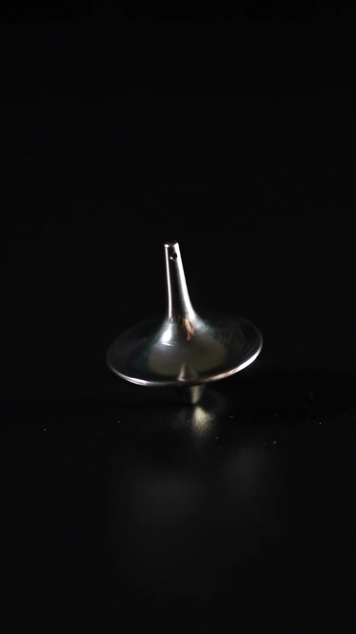 Hand spinning a top on a surface