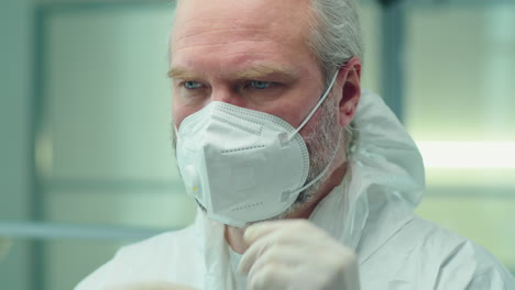 senior doctor putting on protective uniform