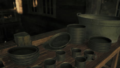 rustic kitchen with metal plates, cups, and bucket