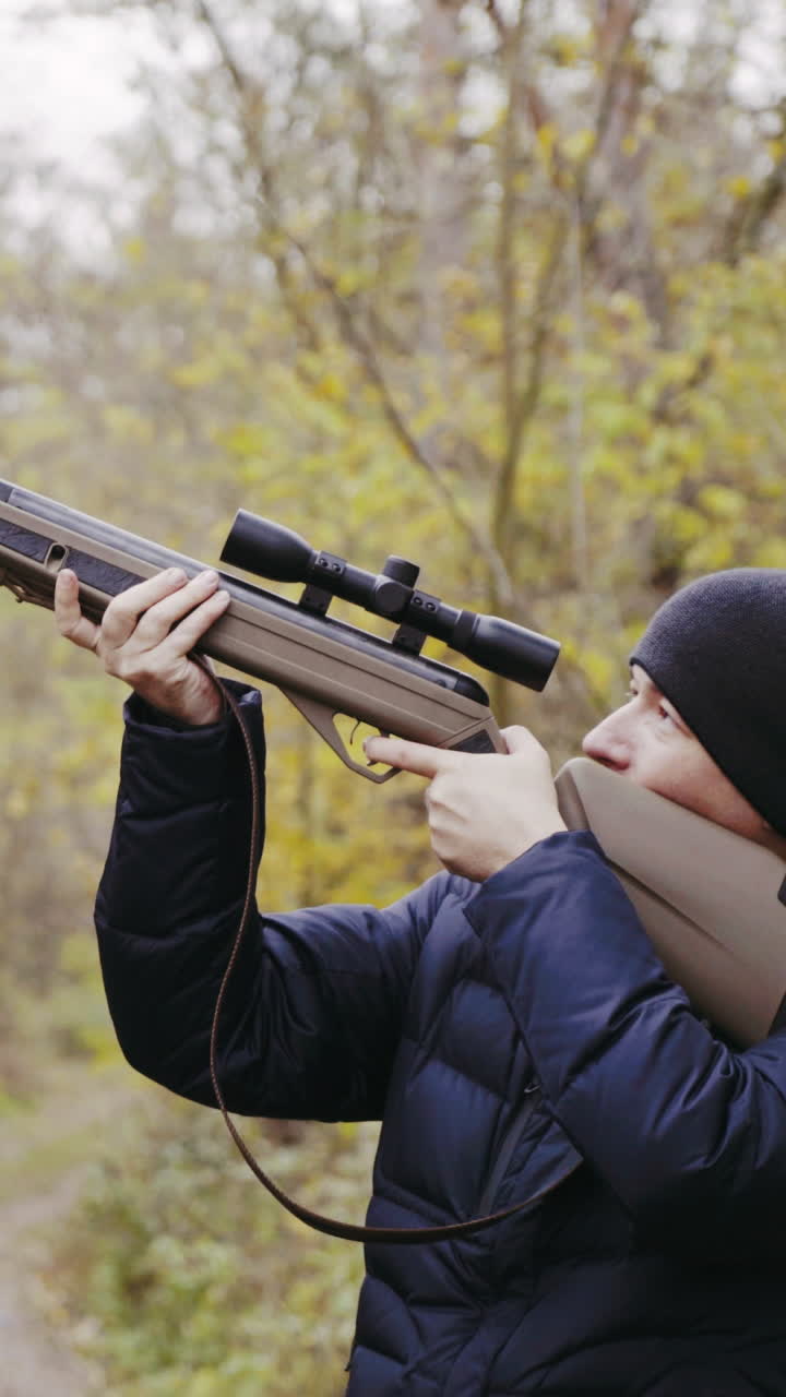 Hunter aiming for wildlife. Close up of hunter aiming down his rifle in autumn season