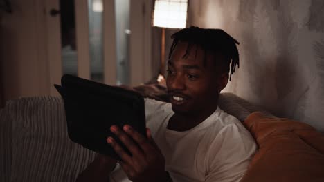 Young-black-male-plays-a-game-intently-on-his-a-tablet-device