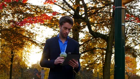 hombre de negocios tomando café mientras usa una tableta digital