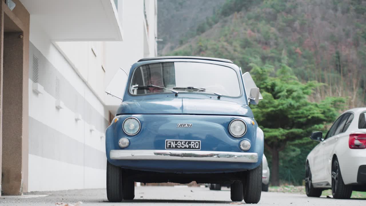 Close-up of a classic Fiat 500 driving past the camera. Vintage car, classic car, retro, nostalgia concept.