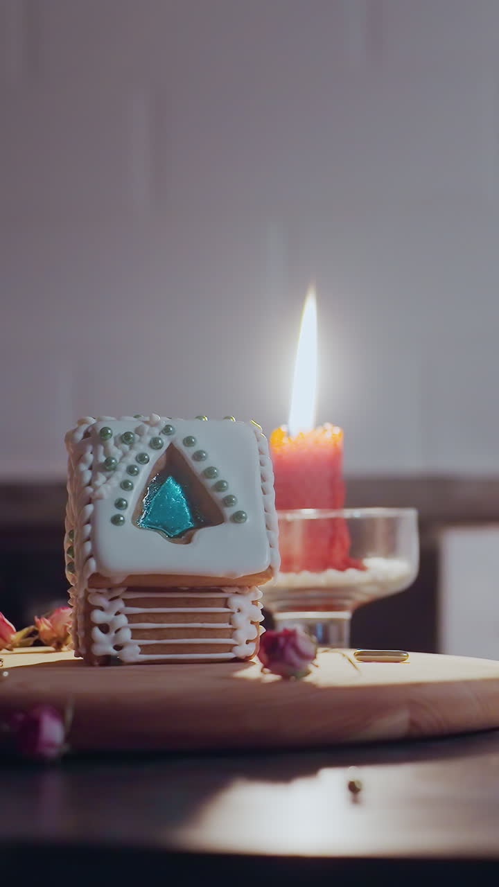 mujer pensativa descansa las manos en la mesa, mirando fijamente la casa de pan de jengibre decorada a la luz de las velas cálidas, la atmósfera acogedora crea un estado de ánimo nostálgico y reflexivo en el entorno de la cocina del hogar