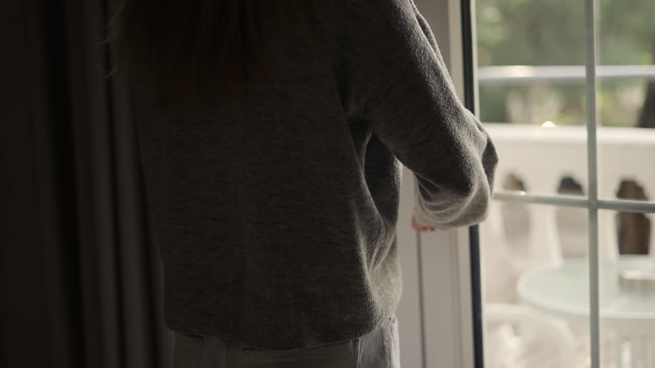 호텔 방 에서 커튼 과 테라스 문 을 닫는 여자