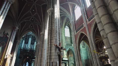 pov of interior of saint bavo's cathedral in ghent, featuring monumental gothic architecture, intricate details, and serene religious ambiance bathed in natural light.