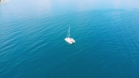 Tourists-enjoying-a-day-sailing-on-a-catamaran-on-the-waves-of-Koh-Kradan,-Thailand---aerial