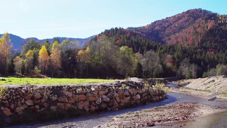 Corrientes-De-Río-Con-Cadenas-Montañosas-Coloridas-En-El-Fondo-Durante-La-Temporada-De-Otoño-En-Las-Montañas-Piatra-Craiului,-Condado-De-Brasov,-Rumania,-Tiro-Estático