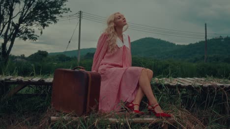 woman with suitcase in a countryside landscape