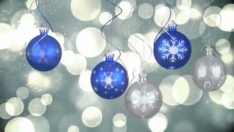 Animation-of-blue-and-silver-christmas-baubles-hanging-and-white-spots-of-light-flickering