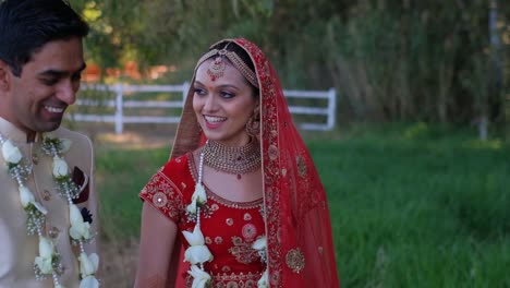 indian groom and bride talking and walking together on their wedding day - medium shot