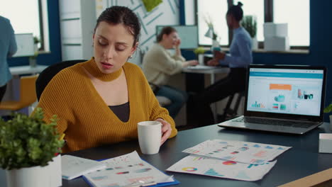 Portrait-of-startup-employee-comparing-two-sheets-of-paper-with-charts-analyzing-financial-data