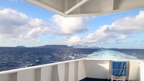Abfahrts-POV-Aussichtspunkt-An-Bord-Eines-Schiffes-Schiff-Fähre-Atlantik-Blauer-Himmel-Wellen-Fernstrecke-Land-Sicht-Weitwinkel-Wolken-Meer-Marine-Passagiere-Reisen-Urlaub-Boot