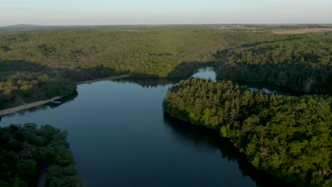 Aerial-shot-over-a-lake-in-the-mountains-surrounded-by-thick-forest-in-Wisconsin,-USA