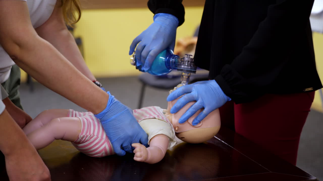 Students practice cpr on a doll. Instructor teaching the proper medical procedure for saving people's life on a dummy.