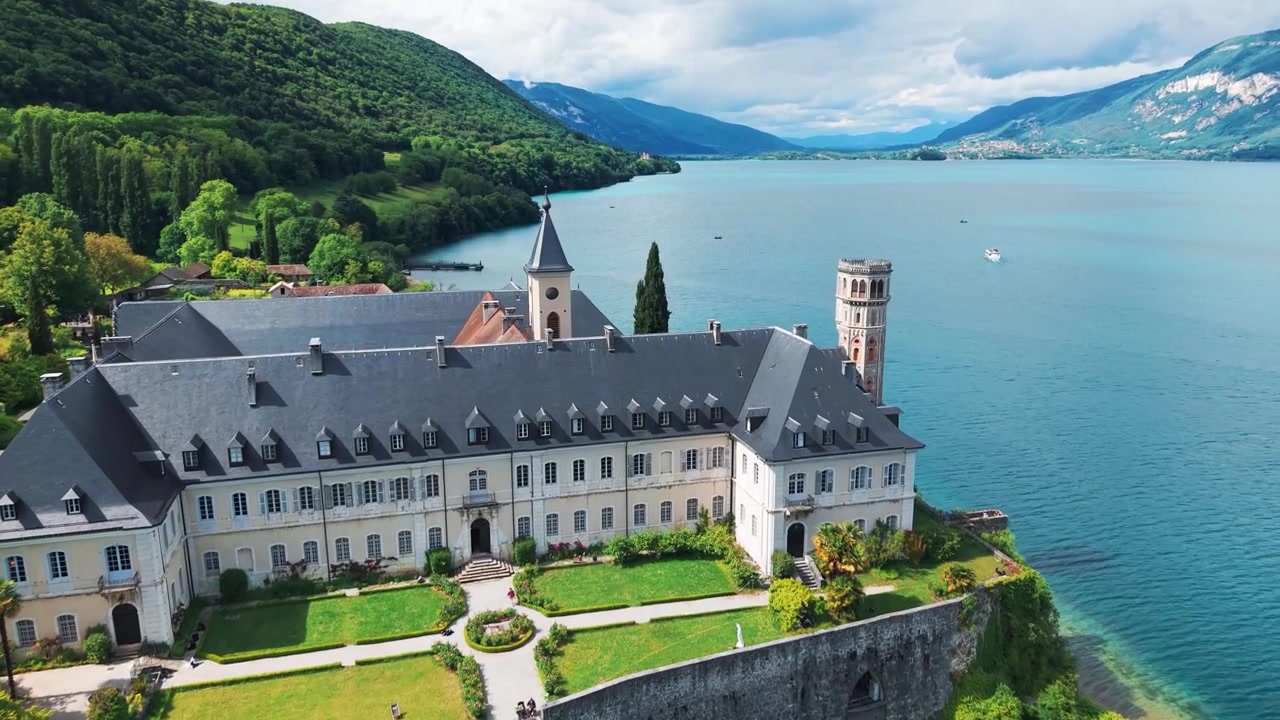 Luftfoto som viser Hautecombe Royal Abbey med Lac du Bourget i bakgrunnen på en solrik vårdag nær Aix les Bains, Savoie-departementet, Auvergne-Rhône-Alpes-regionen, Frankrike.