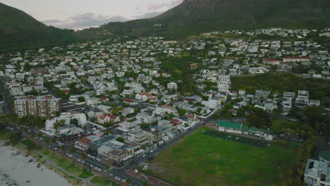 Volar-Por-Encima-Del-Suburbio-Residencial.-Edificios-Bajos-A-Lo-Largo-De-Calles-Rodeadas-De-Vegetación-Verde.-Ciudad-Del-Cabo,-Sudáfrica